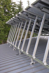 Standing seam roofs suitable for S-5 clamps allow solar arrays to be attached without penetrating the roof.  This array is a bit unusual as it is racked up on a reversed pitch (north facing) shed roof and uses a combination of S-5 clamps plus a number of Unirac FastFoot mounting plates for extra strength. 